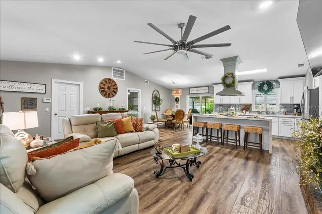a dining room with furniture a chandelier and wooden floor