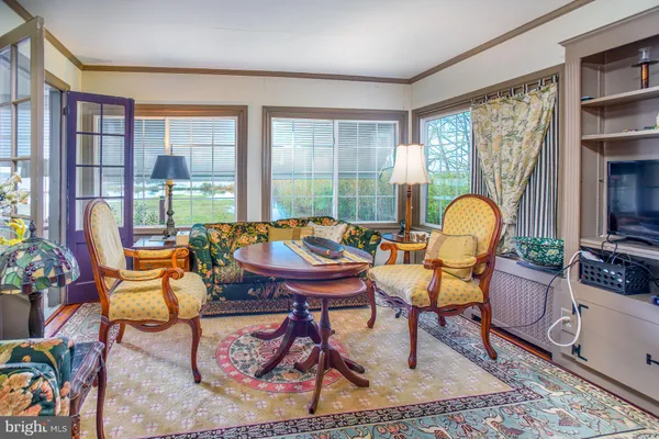 a kitchen with stainless steel appliances granite countertop wooden cabinets a sink a stove a dining table and chairs