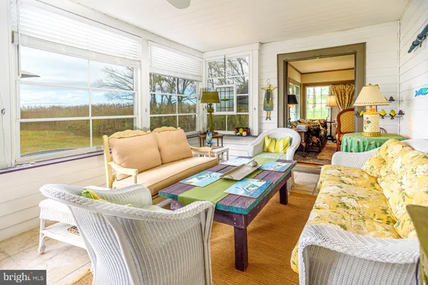 a dining room with furniture a rug and a floor to ceiling window