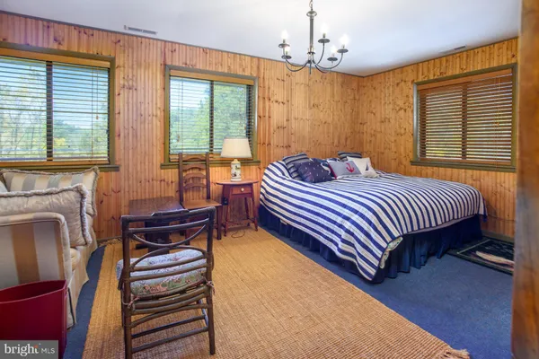 a room with lots of wooden furniture and a chandelier