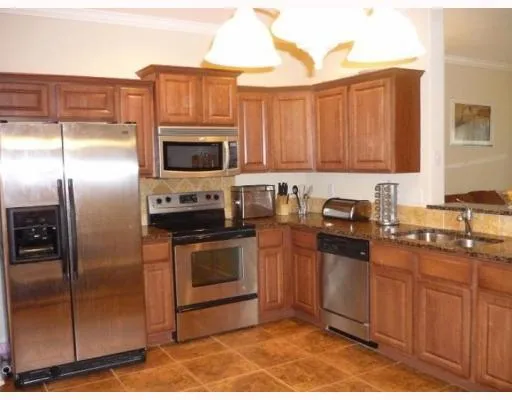 a kitchen with stainless steel appliances granite countertop a stove a refrigerator and a sink
