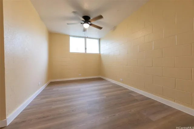 a view of an empty room with a chandelier fan