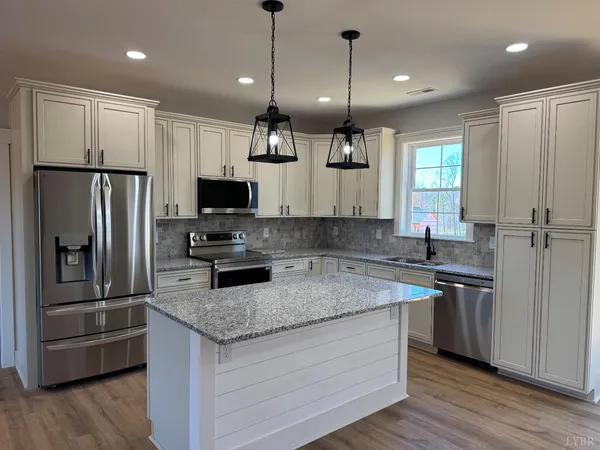 a kitchen with a center island and stainless steel appliances