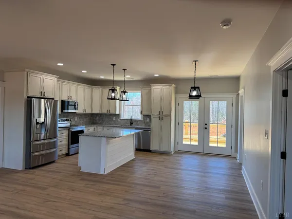 a kitchen with stainless steel appliances granite countertop a refrigerator a sink dishwasher a stove and a refrigerator