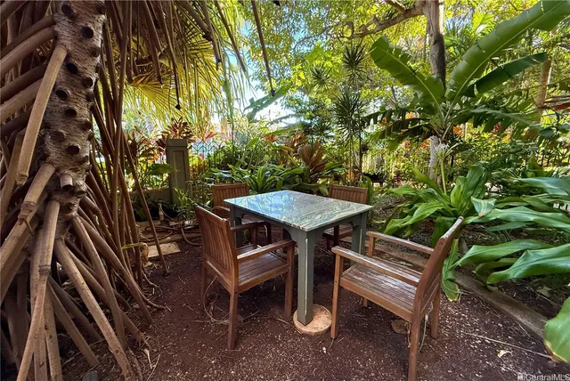 a view of a patio with a table chairs and a barbeque
