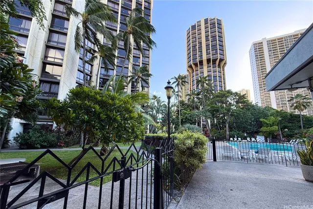 a view of a house with a yard and coconut trees