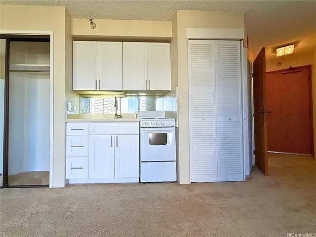 an empty room with a kitchen and a window