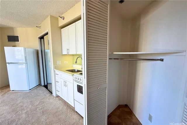 a view of a kitchen with a sink and refrigerator