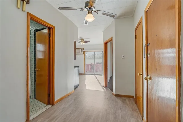 a view of a hallway with wooden floor and closet area