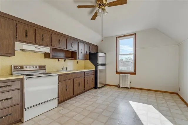 a kitchen with a stove a sink and cabinets