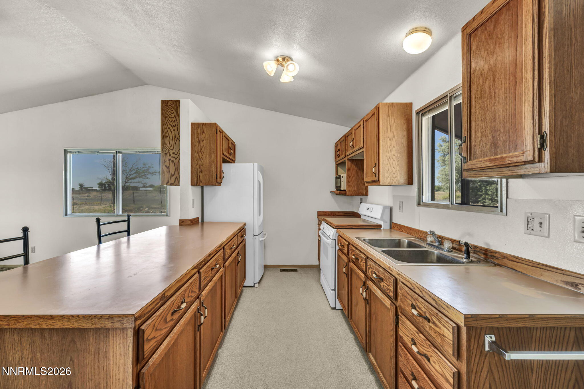 5250 Stillwater Road Fallon, NV 89406 - Photo 14 of 53 a kitchen with stainless steel appliances a sink a stove top oven a counter space and cabinets