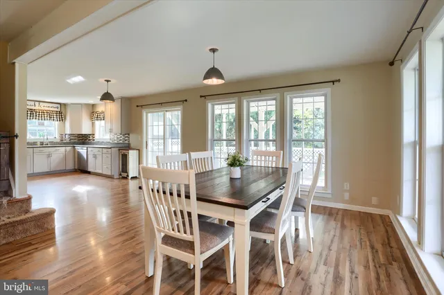 a dining room with stainless steel appliances granite countertop furniture wooden floor and a rug