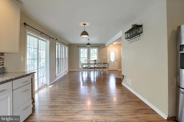 a view of empty room with wooden floor and floor to ceiling window