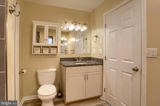 a bathroom with a granite countertop sink toilet and shower
