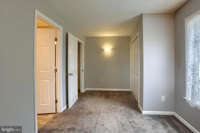 an empty room with windows and closet