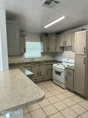 a kitchen with a stove sink and cabinets