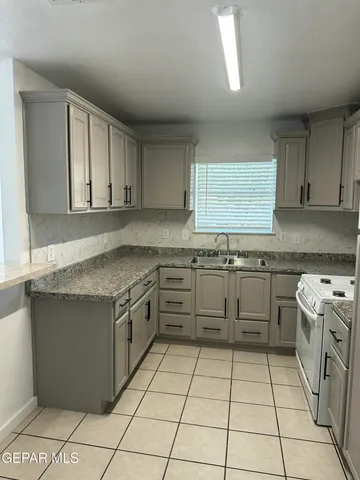 a kitchen with a stove top oven sink and cabinets