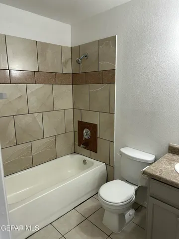 a white toilet sitting next to a bathtub