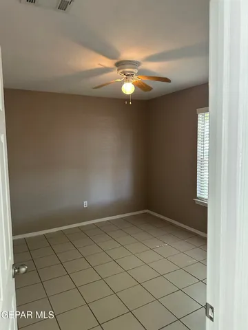 en empty room with windows and ceiling fan
