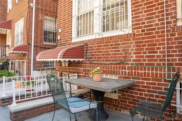 a backyard of a house with barbeque oven table and chairs