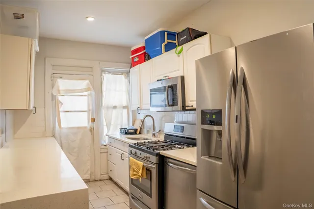 a kitchen with stainless steel appliances granite countertop a refrigerator a stove and a sink with wooden floor