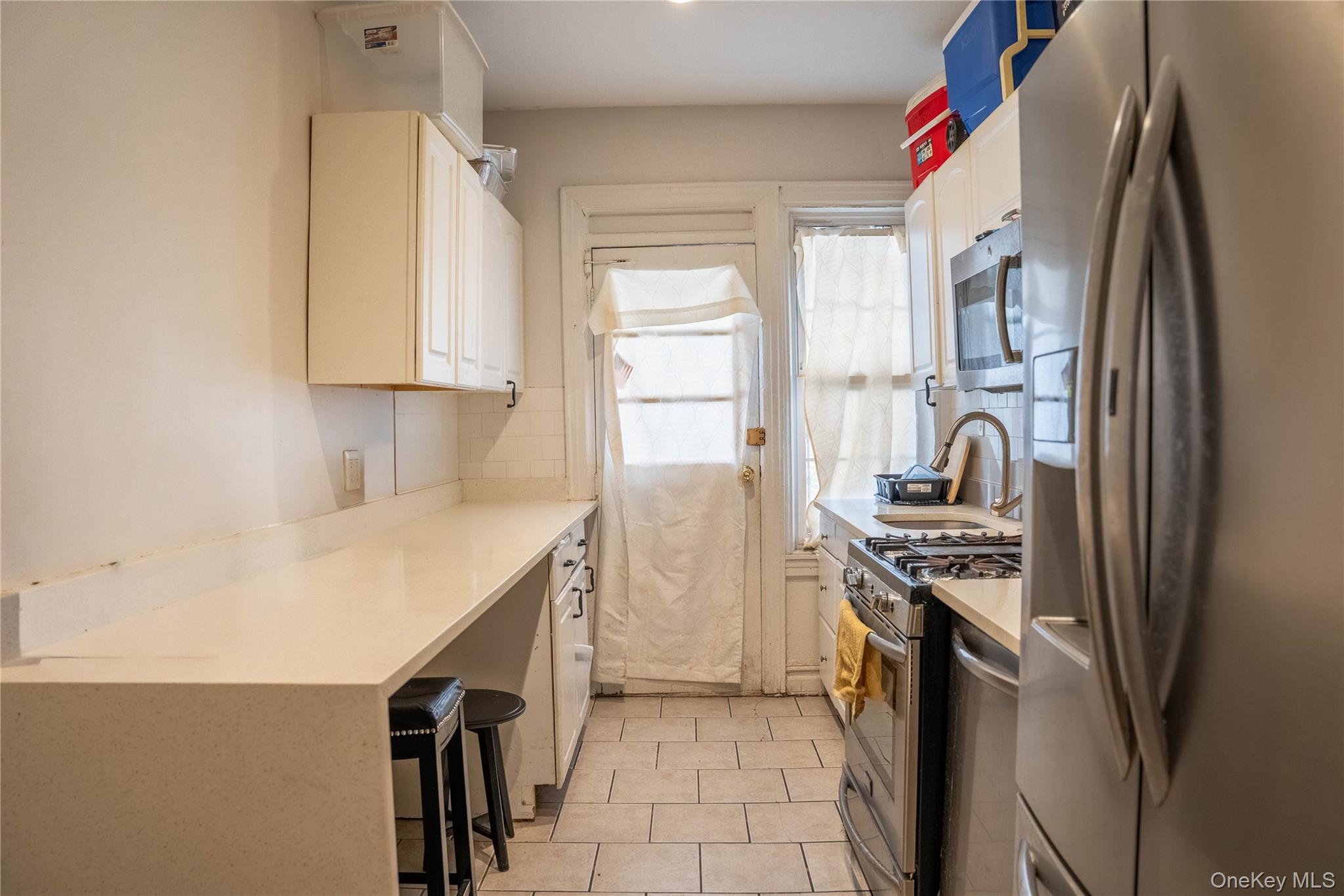 33-26 83rd Street Queens, NY 11372 - Photo 8 of 19 a kitchen with stainless steel appliances a stove a sink and a refrigerator
