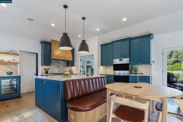 a kitchen with kitchen island a stove a sink a dining table and chairs