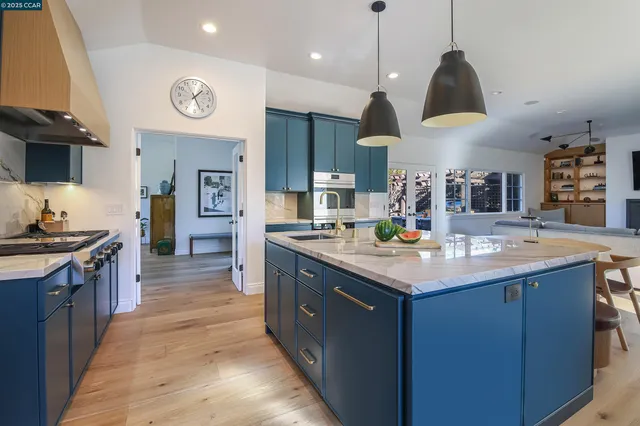 a kitchen with a stove kitchen island a sink and a stove
