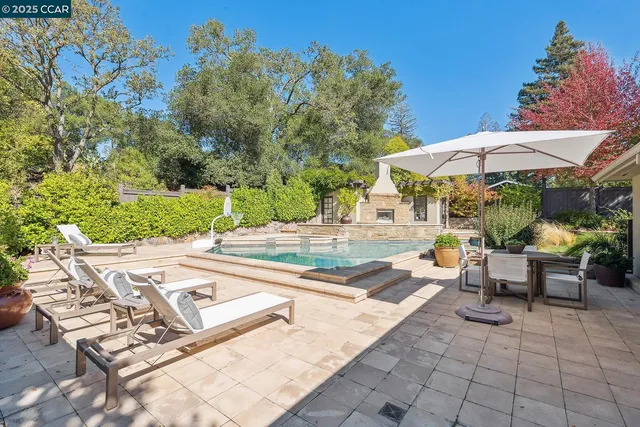 a view of a patio with a table and chairs under an umbrella