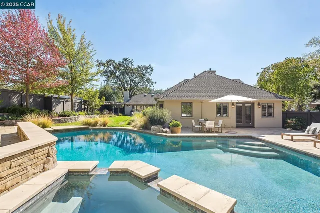 a view of a house with swimming pool and sitting area