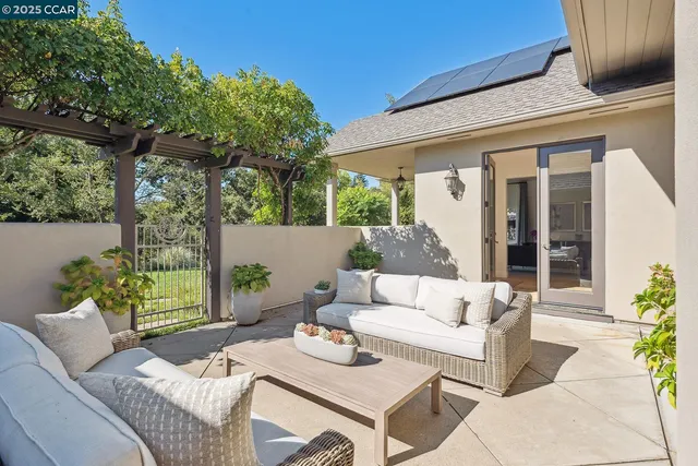 a view of a patio with couches table and chairs and potted plants