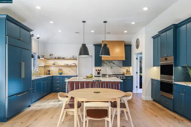a kitchen with a table chairs refrigerator and microwave