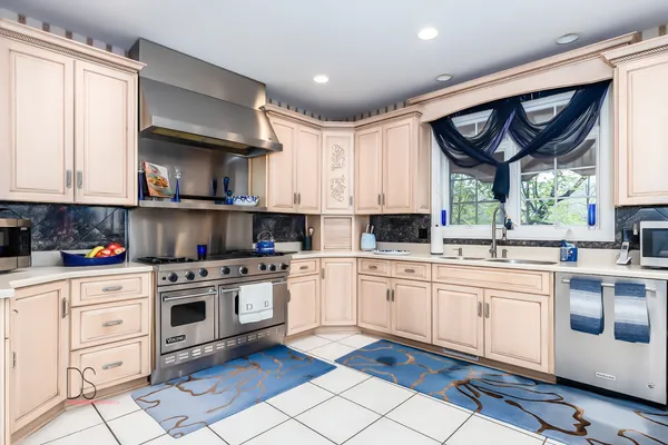 a kitchen with stainless steel appliances granite countertop a stove and white cabinets