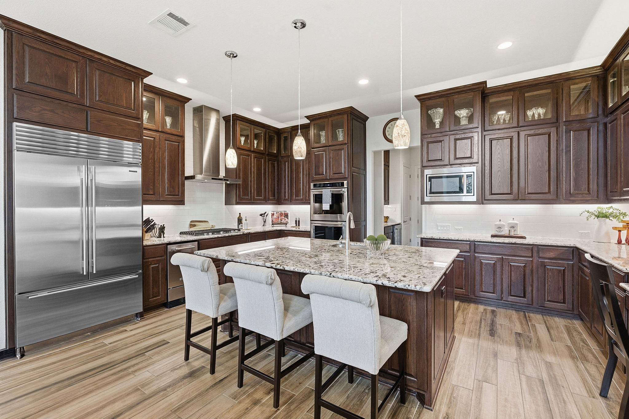 2824 Wedgescale Pass Leander, TX 78641 - Photo 5 of 40 The gourmet kitchen features showcase cabinetry with under-cabinet lighting, white subway tile backsplash, Delicatus White granite countertops and stainless steel appliances