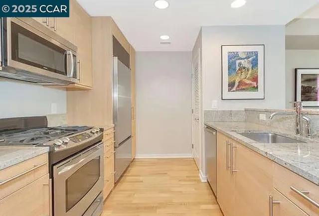 a kitchen with stainless steel appliances granite countertop a stove a sink and a microwave