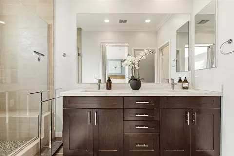a bathroom with a double vanity sink mirror and shower