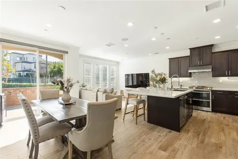 a kitchen with a dining table chairs and flat screen tv