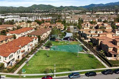 a view of swimming pool with lawn chairs and palm trees