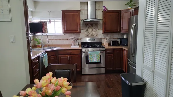 a kitchen with stainless steel appliances granite countertop a stove a sink and a refrigerator