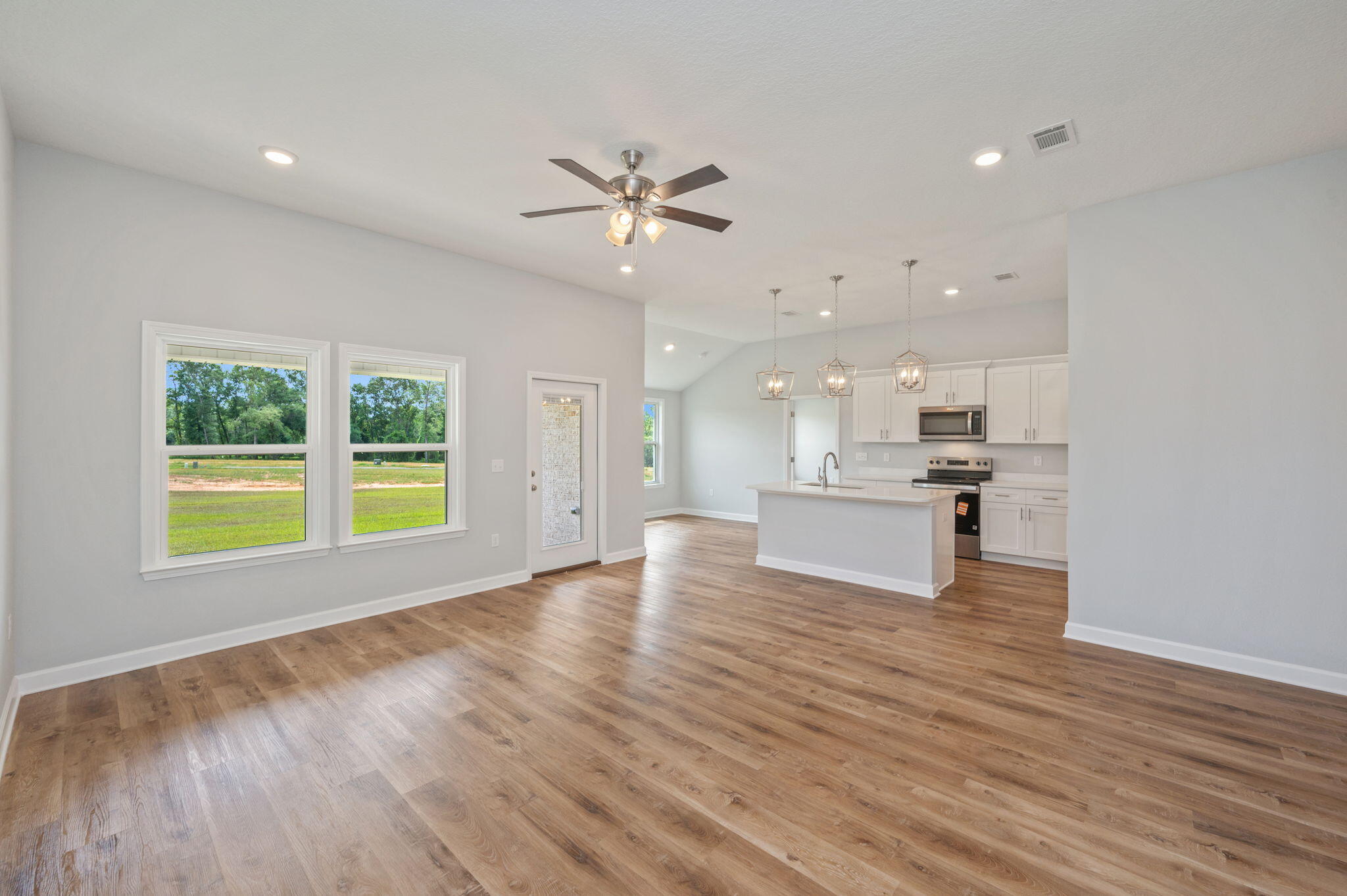 3851 Poverty Creek Road Crestview, FL 32539 - Photo 5 of 32 a view of an empty room with a kitchen and wooden floor