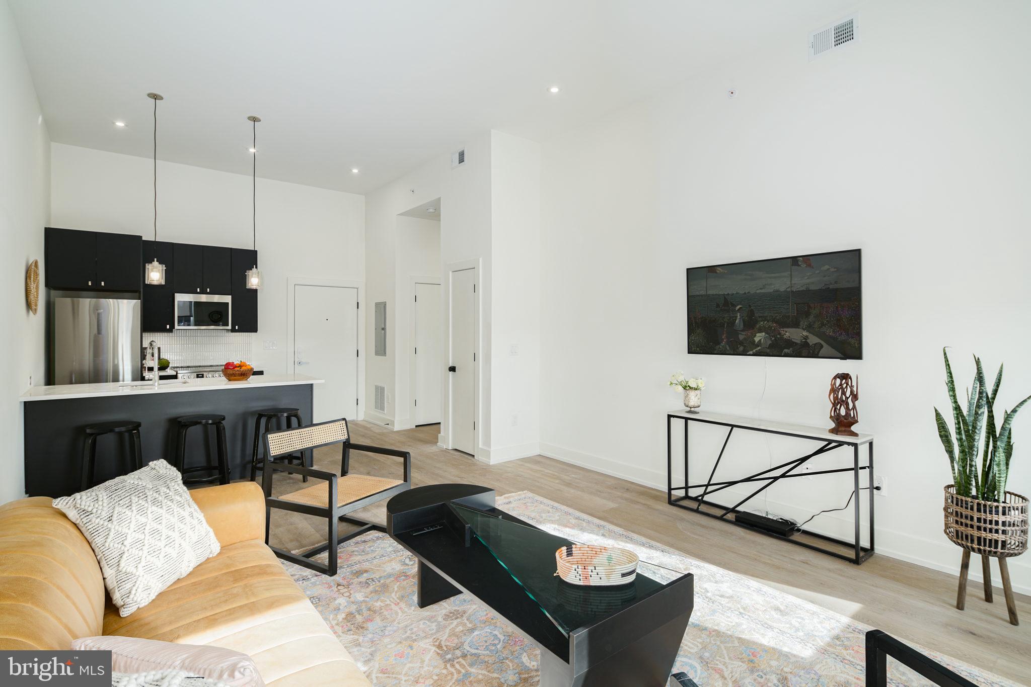 5013 Springfield Avenue, Unit 515 Philadelphia, PA 19143 - Photo 5 of 21 a living room with furniture and a flat screen tv