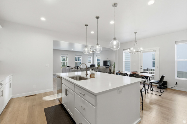 1038 South Old Towne Road Layton, UT 84041 - Photo 4 of 39 Spacious kitchen island with a stainless steel sink and modern pendant lighting