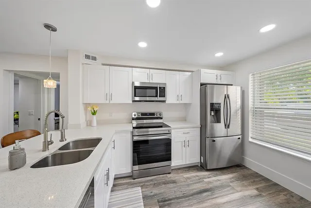 a kitchen with white cabinets and stainless steel appliances