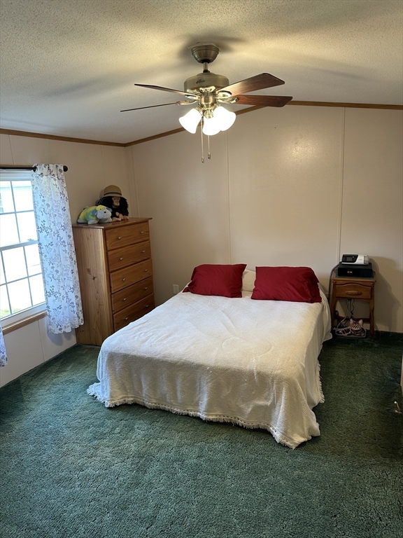 72 Quaboag Valley, Unit 70 Palmer, MA 01069 - Photo 15 of 21 a bedroom with a bed and a chandelier
