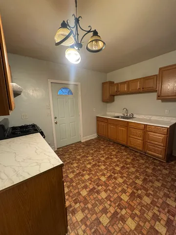 a kitchen with stainless steel appliances kitchen island granite countertop a stove a sink and a refrigerator