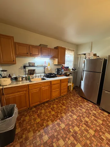 a kitchen with granite countertop a refrigerator and a stove top oven