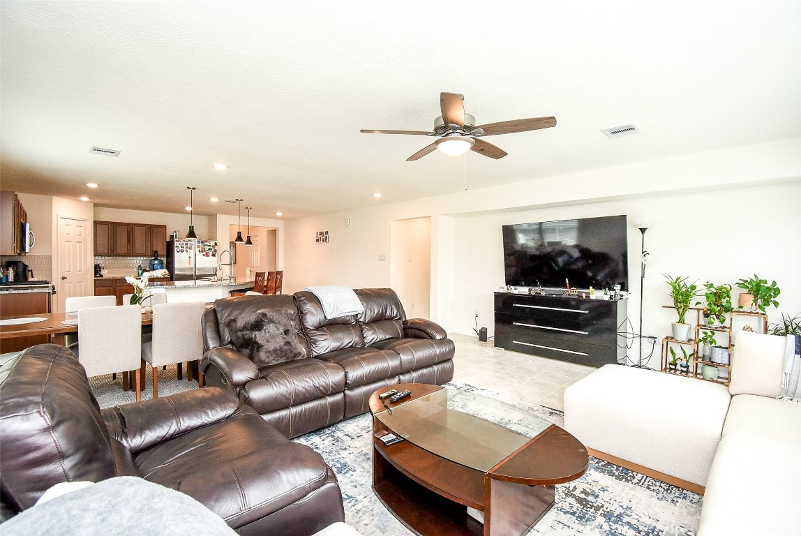 5912 Whitewing Road Rosenberg, TX 77469 - Photo 12 of 25 Spacious, open-concept living room with modern finishes, abundant natural light, and seamless flow to the kitchen—perfect for entertaining and relaxation.