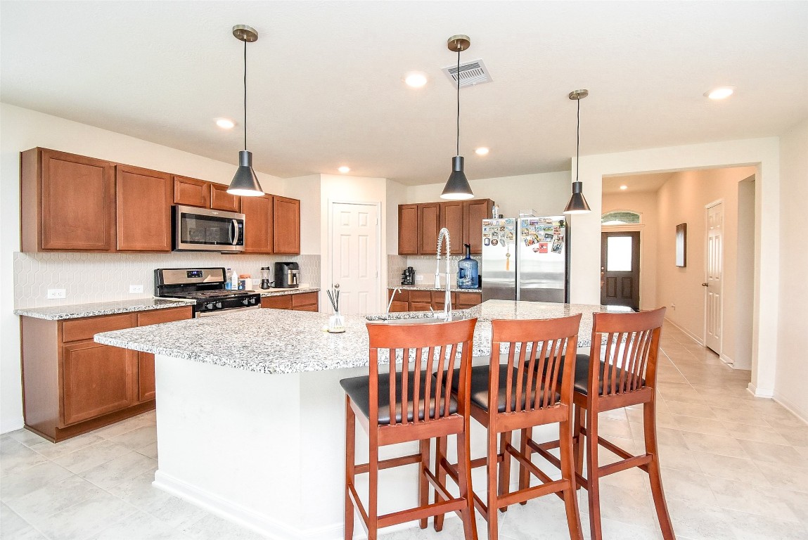 5912 Whitewing Road Rosenberg, TX 77469 - Photo 15 of 25 Spacious kitchen with modern appliances, elegant cabinetry, and a large granite island perfect for entertaining.