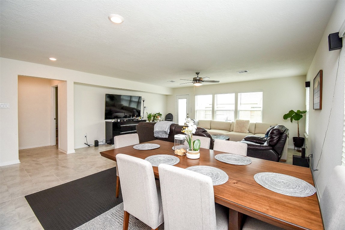 5912 Whitewing Road Rosenberg, TX 77469 - Photo 16 of 25 Elegant dining area seamlessly connects to a spacious living room, perfect for entertaining and family gatherings. Ample natural light enhances the inviting atmosphere.