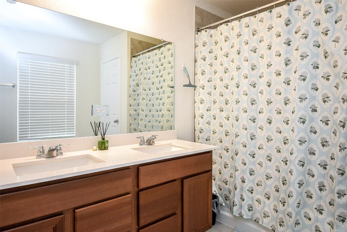 5912 Whitewing Road Rosenberg, TX 77469 - Photo 19 of 25 Luxurious bathroom featuring a double vanity, stylish fixtures, and a bright, inviting atmosphere.